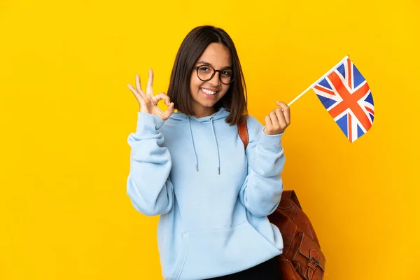 Młoda Latynoska Kobieta Trzyma Flagę Zjednoczonego Królestwa Izolowane Żółtym Tle — Zdjęcie stockowe