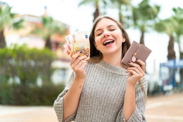 Νεαρή Όμορφη Ξανθιά Γυναίκα Κρατώντας Πορτοφόλι Χρήματα Χαρούμενη Έκφραση — Φωτογραφία Αρχείου