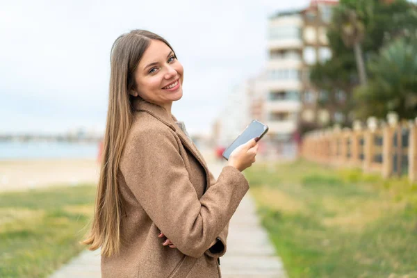 Genç Güzel Sarışın Bir Kadın Cep Telefonu Tutuyor Kollarını Kavuşturuyor — Stok fotoğraf