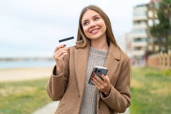 Νεαρή Όμορφη Ξανθιά Γυναίκα Αγοράζει Κινητό Πιστωτική Κάρτα Ενώ Σκέφτεται — Φωτογραφία Αρχείου