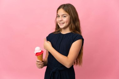 Kornet dondurması ile izole edilmiş pembe arka planı olan çocuk...
