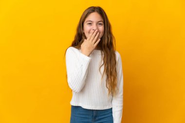 İzole edilmiş sarı arka plandaki çocuk mutlu ve gülümsüyor.