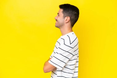 Sarı arka planda, yalıtılmış genç ve yakışıklı bir adam var.