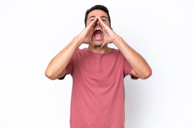 Soyutlanmış beyaz arka planda genç yakışıklı bir adam bağırıyor ve bir şeyler söylüyor.