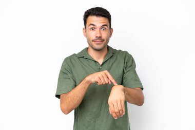 Soyutlanmış beyaz arka planda genç yakışıklı adam geç kalma jesti yapıyor.