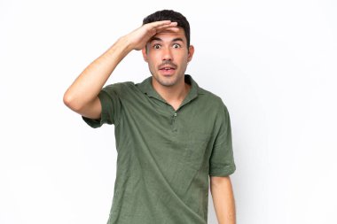 Soyutlanmış beyaz arka planda genç yakışıklı bir adam. Bir şeye bakmak için çok uzaklara bakıyor.