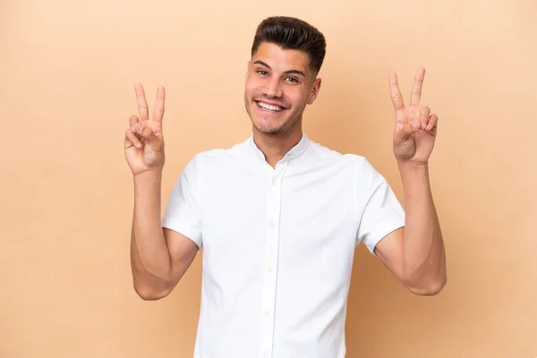 Young Caucasian Man Isolated Beige Background Showing Victory Sign Both — Foto Stock