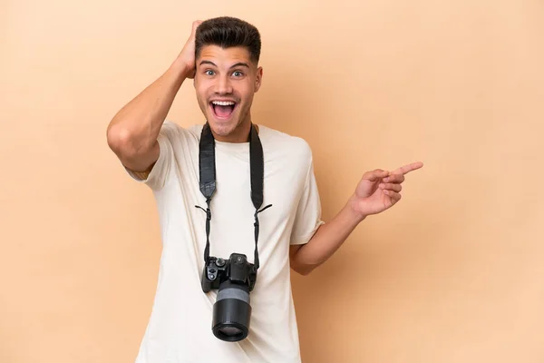 Young Photographer Caucasian Man Isolated Beige Background Surprised Pointing Finger — Stock Photo, Image
