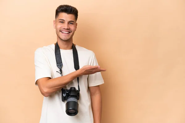 年轻的摄影师高加索人 因米色背景而与世隔绝 面带微笑地向前方看去 提出了一个想法 — 图库照片