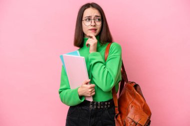 Genç Ukraynalı kadın pembe arka planda izole edilmiş şüpheleri ve düşünceleri var.