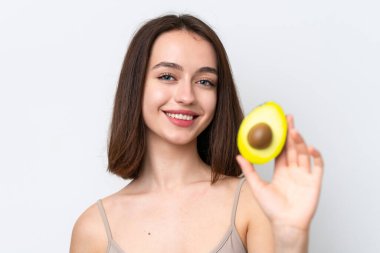 Genç Ukraynalı bir kadın beyaz arka planda izole edilmiş, elinde avakado tutarken gülümsüyor. Portreyi kapat