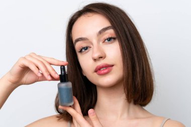 Beyaz arka planda izole edilmiş genç Ukraynalı kadın elinde bir serum tutuyor. Portreyi kapat