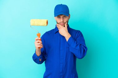 Kafkasyalı ressam mavi arka planda izole edilmiş.