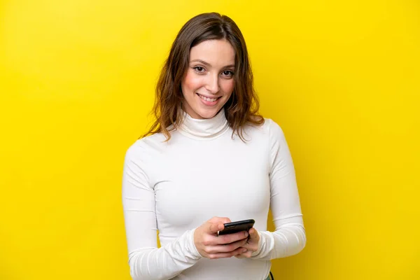 Sarı Arka Planda Izole Edilmiş Genç Beyaz Kadın Cep Telefonuyla — Stok fotoğraf