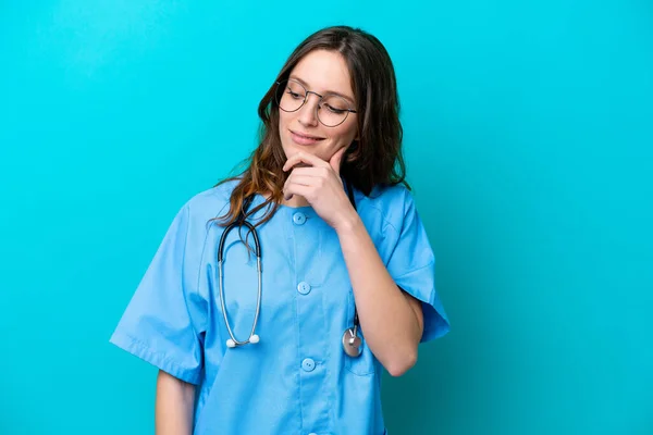 Ung Kirurg Läkare Kvinna Isolerad Blå Bakgrund Tittar Sidan Och — Stockfoto