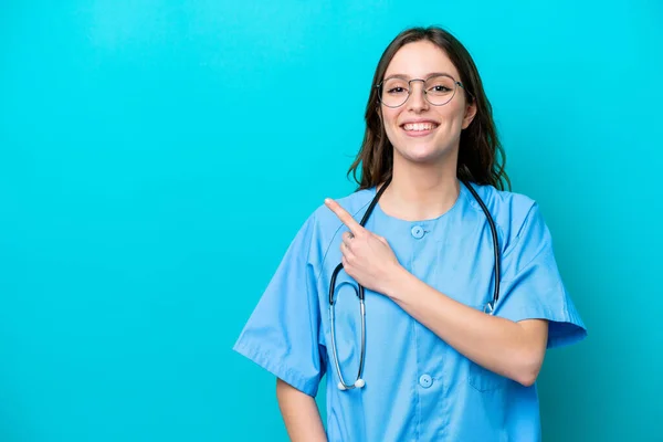Молода Жінка Хірург Ізольована Синьому Фоні Вказуючи Бік Щоб Представити — стокове фото