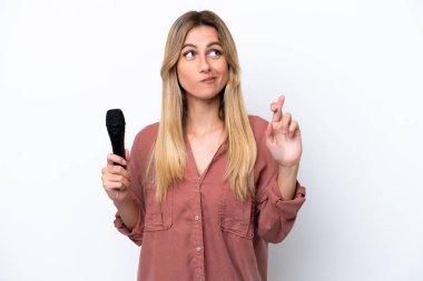 Şarkıcı Uruguaylı kadın beyaz arka planda izole edilmiş bir mikrofonu kaldırıyor ve en iyisini diliyor.