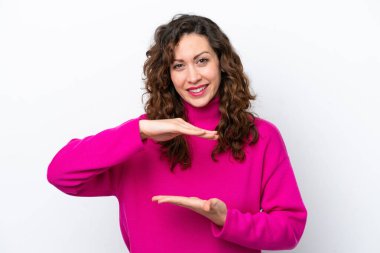 Beyaz arka planda izole edilmiş genç beyaz kadın bir ilan vermek için avucunun içinde hayali bir fotokopi makinesi tutuyor.