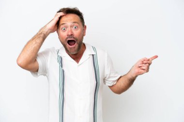 Beyaz arka planda izole edilmiş orta yaşlı beyaz bir adam şaşırmış ve parmağıyla kenarı işaret ediyor.