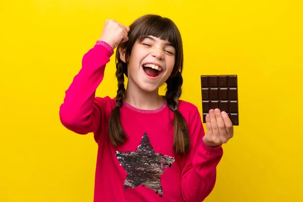 Malá Kavkazská Dívka Čokoládou Izolované Žlutém Pozadí Slaví Vítězství — Stock fotografie