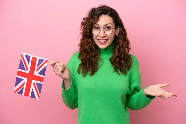 Mladá Běloška Drží Anglickou Vlajku Izolované Růžovém Pozadí Šokovaným Výrazem — Stock fotografie