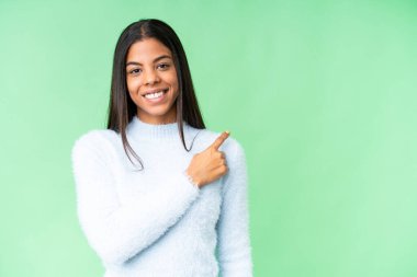 Young African American woman over isolated chroma key background pointing to the side to present a product