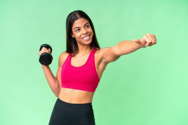 Genç Afrikalı Amerikalı kadın spor kadın halterci izole edilmiş krom anahtar arka plan üzerinde ağırlık kaldırıyor. Baş parmak hareketi yapıyor.