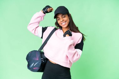 Young sport African American woman with sport bag over isolated chroma key background celebrating a victory