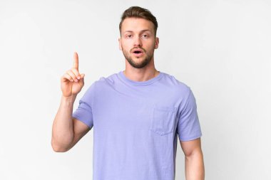 İzole edilmiş beyaz arka planda genç, yakışıklı beyaz bir adam bir fikri işaret ederek...