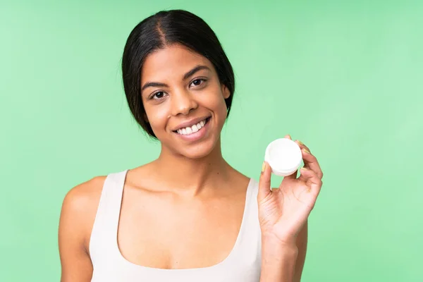 stock image Young woman over over isolated chroma key background with moisturizer and happiness