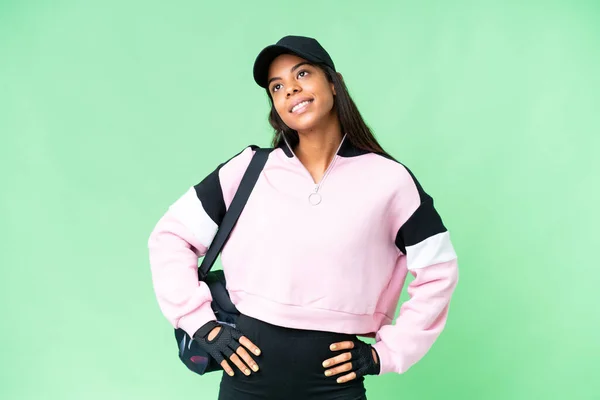 年轻的非裔美籍体育女子 头戴运动包 背负孤立的彩色关键背景 双手叉腰 面带微笑 — 图库照片