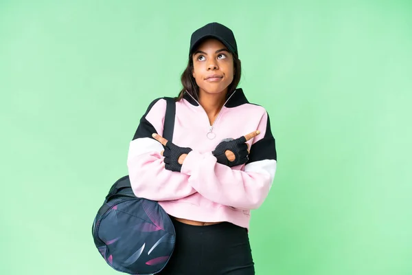 年轻的非裔美籍体育女子 身披运动包 背负着孤立的彩色关键背景 指向侧边有疑问的地方 — 图库照片