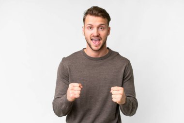 Soyutlanmış beyaz bir arkaplanda zafer kutlayan yakışıklı beyaz bir adam.