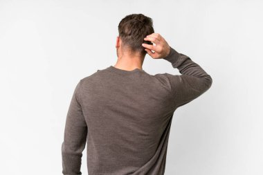 Beyaz arka planda beyaz tenli, yakışıklı beyaz bir adam var.