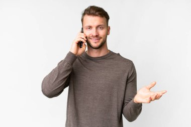 İzole edilmiş beyaz bir geçmişi olan yakışıklı beyaz bir adam cep telefonuyla sohbet ediyor.