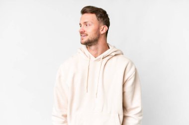 Young handsome caucasian man over isolated white background looking side