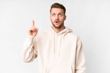 İzole edilmiş beyaz arka planda genç, yakışıklı beyaz bir adam bir fikri işaret ederek...