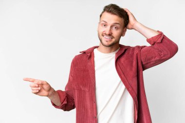 Young handsome caucasian man over isolated white background surprised and pointing finger to the side