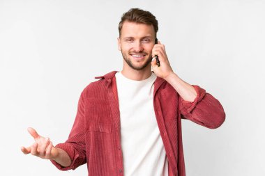 İzole edilmiş beyaz bir geçmişi olan yakışıklı beyaz bir adam cep telefonuyla sohbet ediyor.