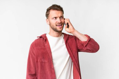 İzole edilmiş beyaz geçmişi olan yakışıklı beyaz bir adam cep telefonuyla sohbet ediyor.