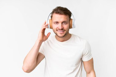 Young handsome caucasian man over isolated white background listening music