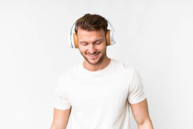 Young handsome caucasian man over isolated white background listening music