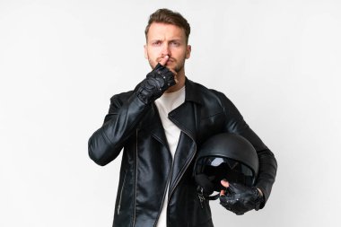 Motosiklet kasklı beyaz arka planı olan genç beyaz bir adam yukarı bakarken şüphe duyuyor.