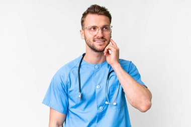 İzole edilmiş beyaz arka planda genç hemşire yukarı bakarken bir fikir düşünüyor.