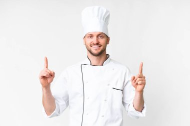 Kafkasyalı genç aşçı izole edilmiş beyaz arka plan harika bir fikre işaret ediyor.