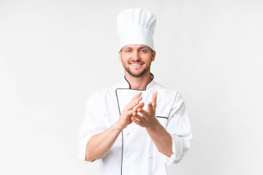 Kafkasyalı genç aşçı, bir konferansta sunumdan sonra beyaz arka planda alkışlıyor.