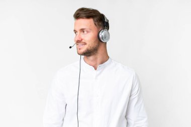 Tele pazarlamacı, beyaz arka plan üzerinde kulaklıkla çalışan beyaz bir adam.