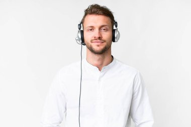 Tele pazarlamacı, beyaz bir arka planda kulaklıkla çalışan beyaz bir adam gülüyor.