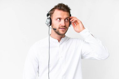 Tele pazarlamacı Kafkasyalı bir adam izole edilmiş beyaz arka plan üzerinde bir kulaklıkla çalışıyor.