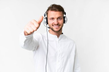 Tele pazarlamacı beyaz kulaklıkla çalışan beyaz bir adam. Başparmakları havada. Çünkü iyi bir şey oldu.